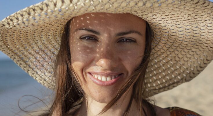 Frau mit Sonnenhut Haarpflege im Sommer