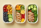Meal Prep in Form von verschiedenen Lebensmitteln und Gerichten in drei Dosen.