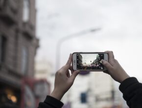 Zwei Hände, die ein Smartphone halten und amit fotografieren.
