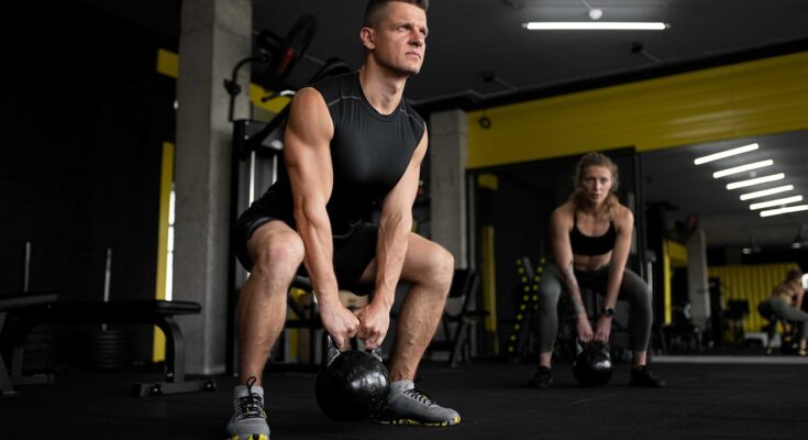Ein Mann und eine Frau in Kniebeuge in einem Fitnessstudio.
