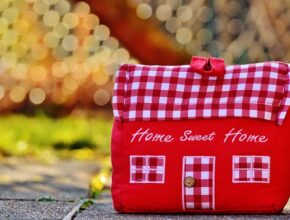 Ein Türstopper aus rotem und rot-kariertem Stoff in Form eines Hauses.