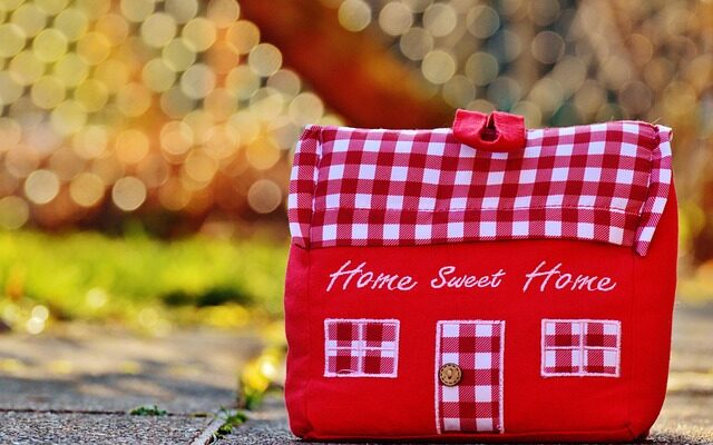 Ein Türstopper aus rotem und rot-kariertem Stoff in Form eines Hauses.